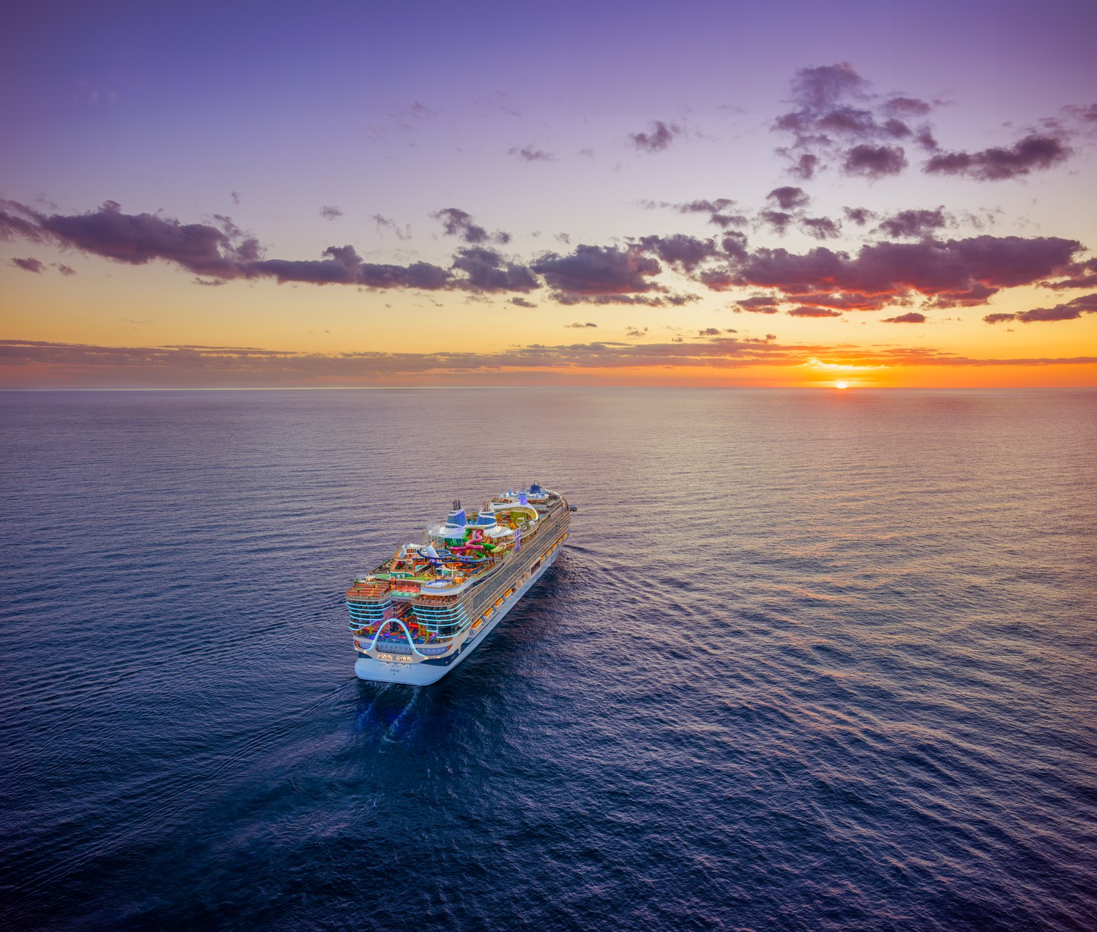 Icon of the Seas at sea at sunset